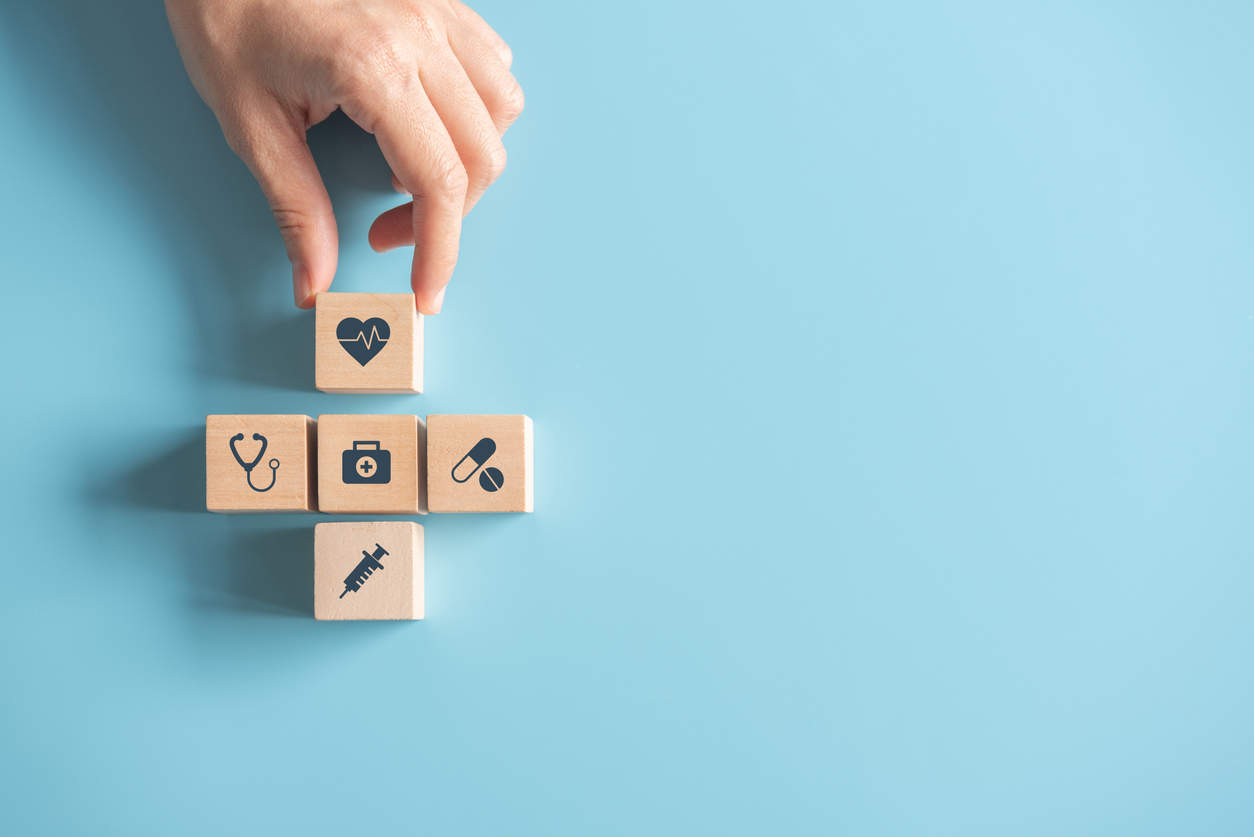 Health medical Insurance Concept, Hand arranging wood cube with medical symbol on pastel blue background, copy space.