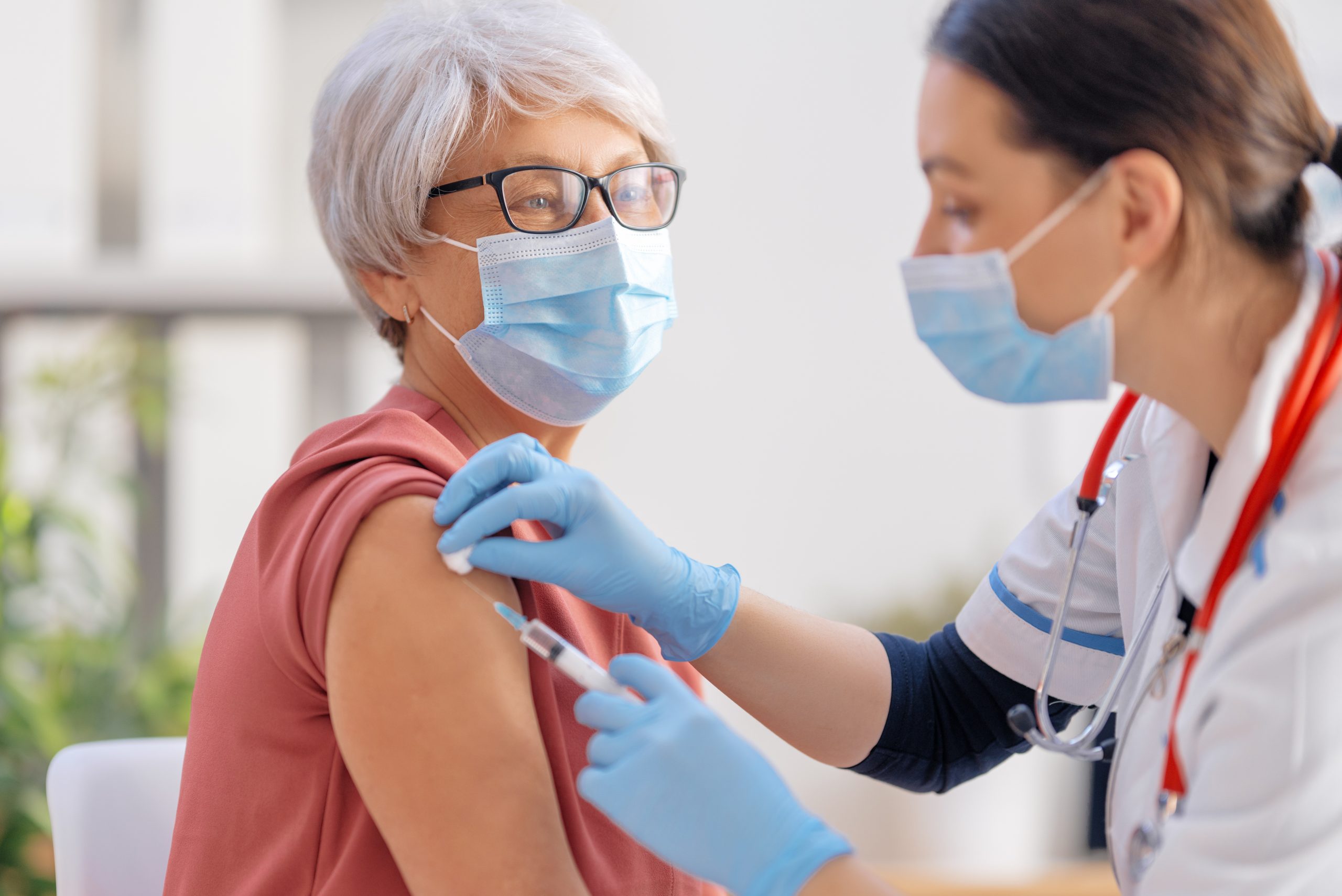 Doctor vaccinating a senior woman